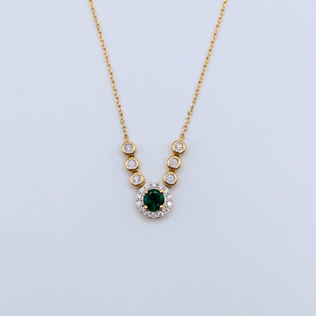 emerald in diamond halo pendant on 18k yellow gold