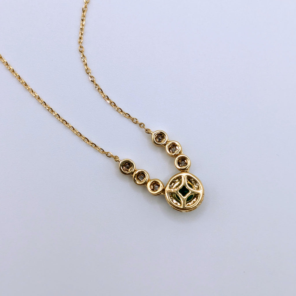 emerald in diamond halo pendant on 18k yellow gold