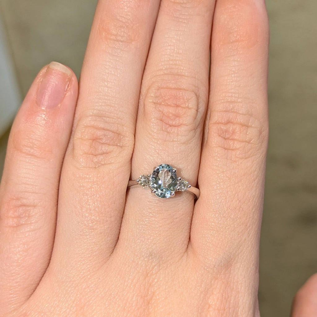 Oval aquamarine with round trilogy ring on 18k white gold