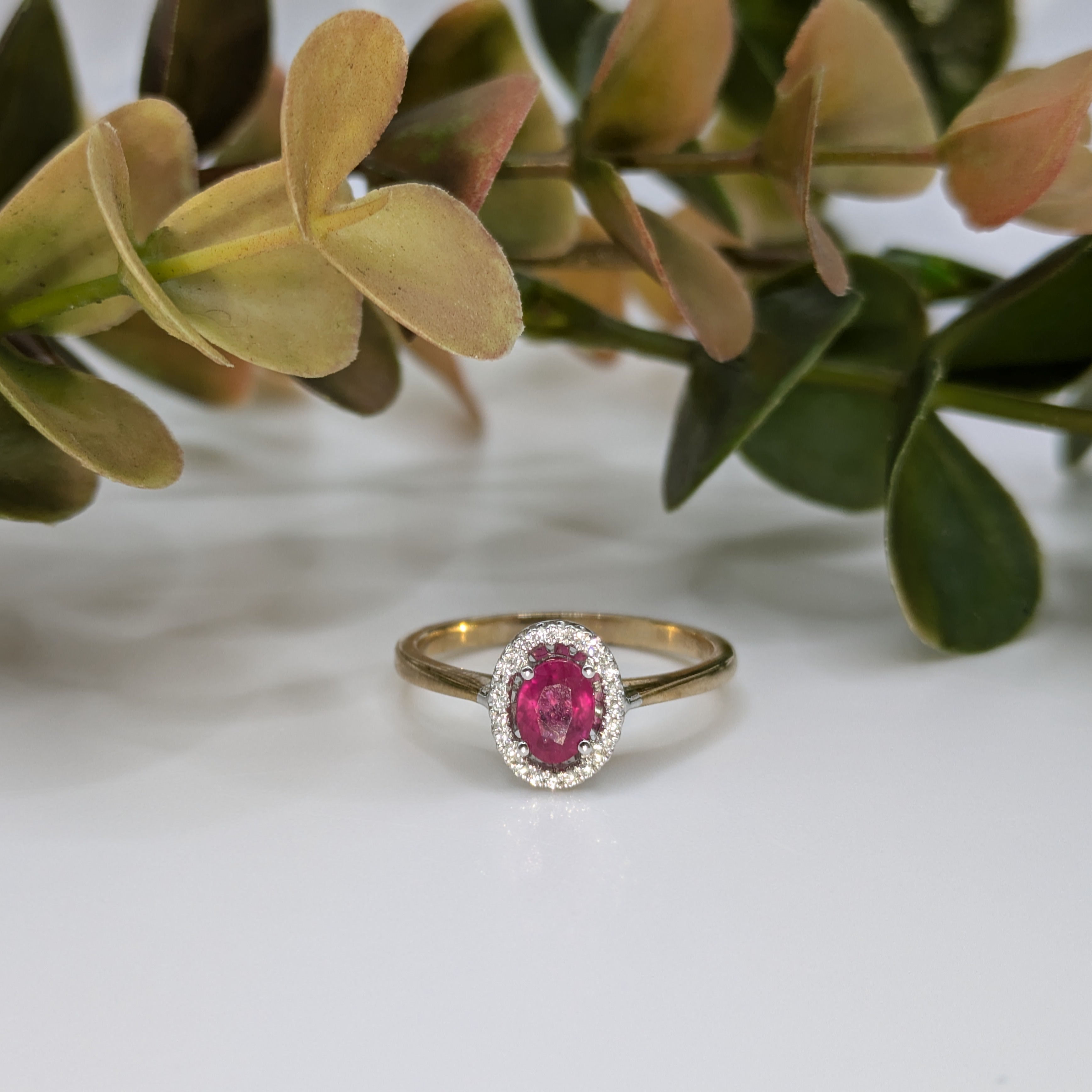 Oval ruby in diamond halo