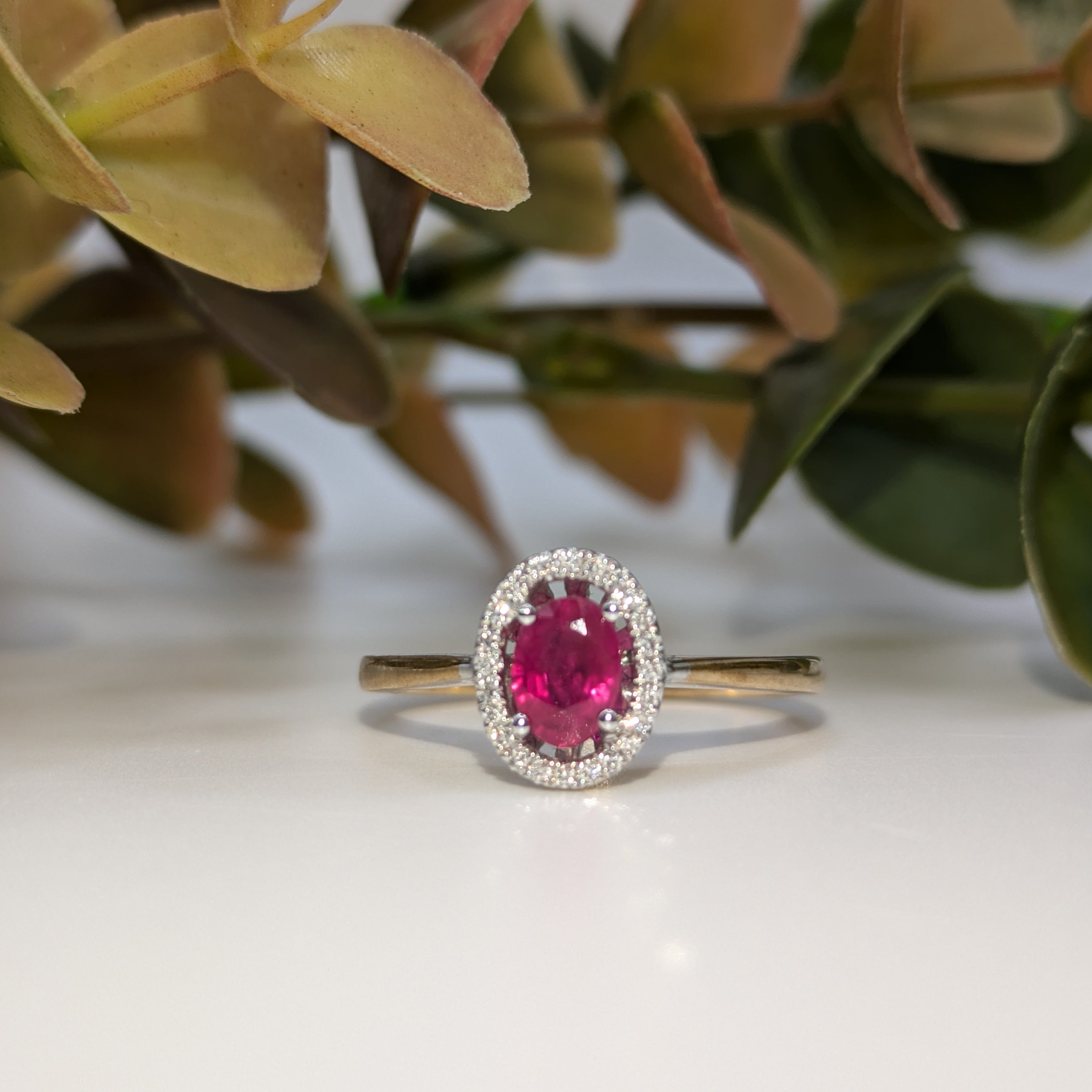 Oval ruby in diamond halo